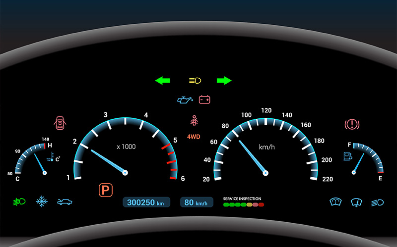 Car dashboard illuminated with speedometers and various warning lights